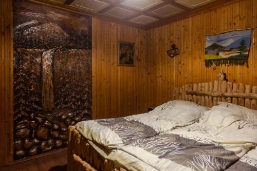 Bett in einem Zimmer mit Wandgemälde in der Unterkunft Файна Чічка in Jaremtsche
