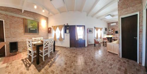 a living room with a brick wall and a table at Rawson casa a minutos del centro y de Playa Unión in Rawson