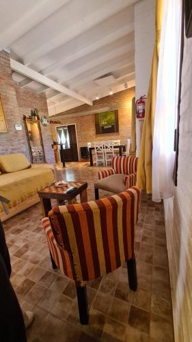 a living room with chairs and a bed and a table at Rawson casa a minutos del centro y de Playa Unión in Rawson