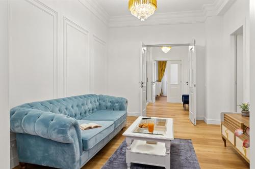 Una sala de estar con un sofá azul y una mesa. en Apartament - Rafinament Arhitectural - Blocul Wilson, en Bucarest