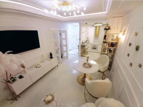 sala de estar con TV, mesa y sillas en Apartament Glamour Okrzei, en Sandomierz