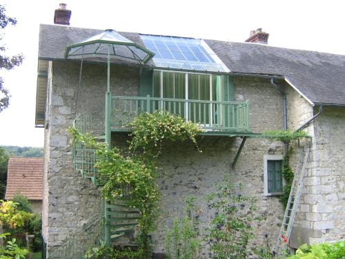 a house with a balcony with a solarium on it at Les Buissonnets in Giverny
