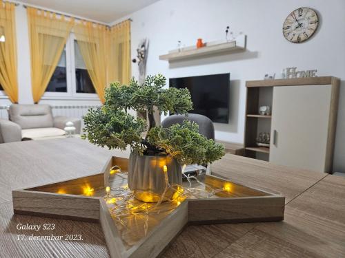 una sala de estar con una mesa con un jarrón con flores en Apartman Vukota 2 Pirot, en Pirot