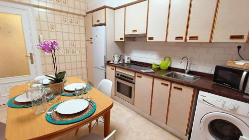 a small kitchen with a table and a sink at Mar y Sol in Bermeo