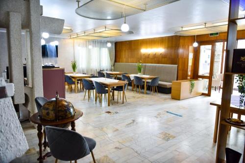 un ristorante con tavoli e sedie in una stanza di Former Ceausescu's Vila Crizantema a Băile Govora