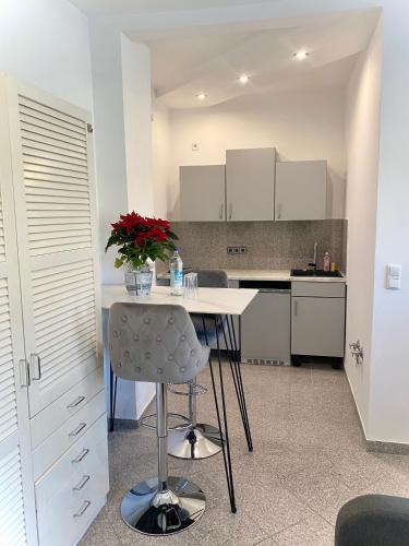 a kitchen with a table with a vase of flowers on it at kleines Apartment, nähe Stadtzentrum im 1ten Obergeschoss in Bamberg