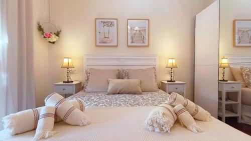 a bedroom with a large white bed with two lamps at Mar y Sol in Bermeo
