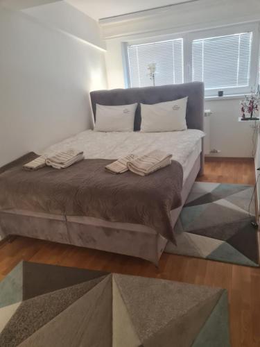 a bedroom with a large bed with two towels on it at Apartman Vip Aleksa Zlatibor Centar in Zlatibor