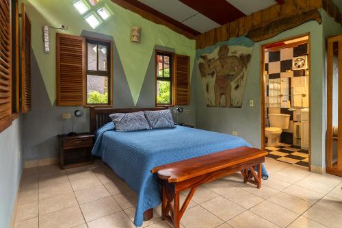 a bedroom with a bed with a blue comforter at Talamanca Nature Reserve in Rivas