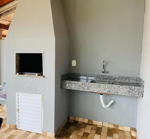 a bathroom with a granite counter top and a sink at Casa Barata Próxima a Praia in Bombinhas