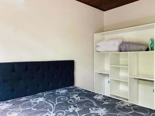 1 dormitorio con 1 cama azul y estanterías blancas en Casa Barata Próxima a Praia, en Bombinhas
