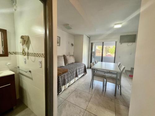Una pequeña sala de estar con una mesa y un sofá. en Tres Estrellas y Un Sol Departamentos, en Valeria del Mar
