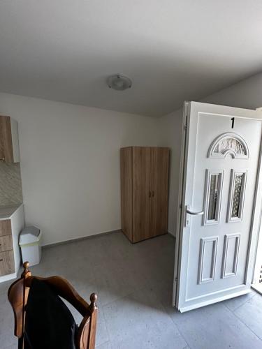 a room with a white door and a wooden cabinet at Apartmani Tamaris in Murter