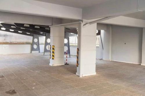 um parque de estacionamento vazio com colunas brancas num edifício em Central appartment3 with parking em Lárissa