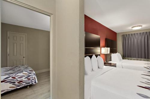 um quarto de hotel com duas camas e um espelho em Red Roof Inn Redding em Redding