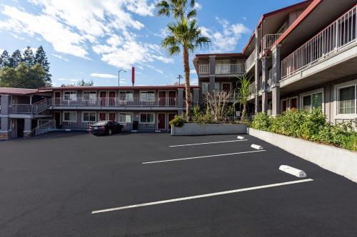 an empty parking lot in front of a building at Red Roof Inn Redding in Redding