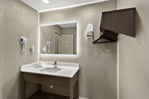 a bathroom with a sink and a mirror at Red Roof Inn Redding in Redding