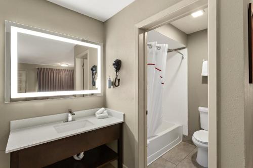 uma casa de banho com um lavatório, um WC e um espelho. em Red Roof Inn Redding em Redding