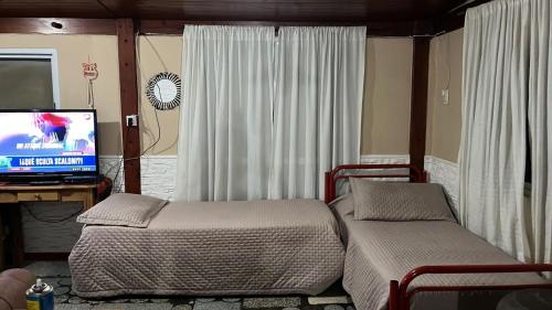 1 dormitorio con 1 cama y escritorio con TV en Gratitud! en Almafuerte