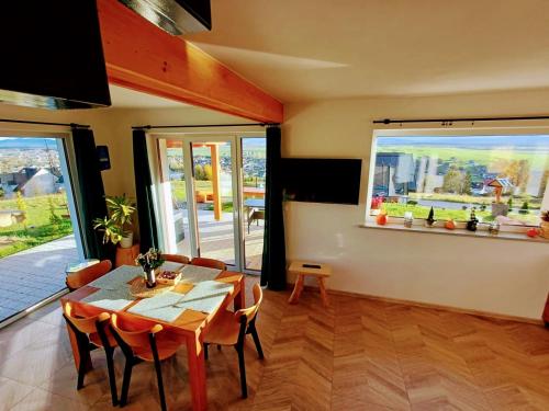 Domek na Wielkiej Górze في Waksmund: غرفة طعام بها طاولة وكراسي ونافذة