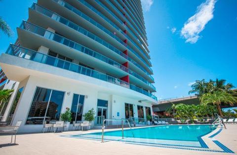 a large building with a swimming pool in front of it at Iconic View - Family 2BR Suite - Hotel - Fiber Internet in Hallandale Beach
