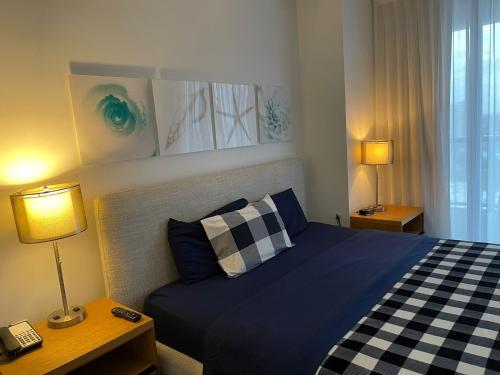 a bedroom with a blue bed and two lamps at Iconic View - Family 2BR Suite - Hotel - Fiber Internet in Hallandale Beach
