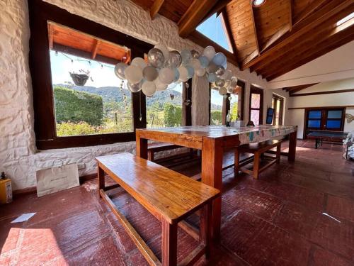 a dining room with wooden tables and a large window at Casa de eventos y descanso in La Calera