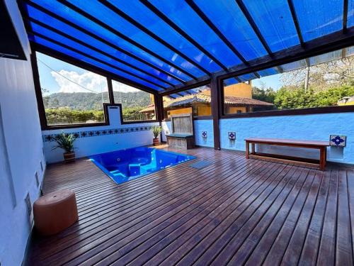 a deck with a bench and a blue pool at Casa de eventos y descanso in La Calera