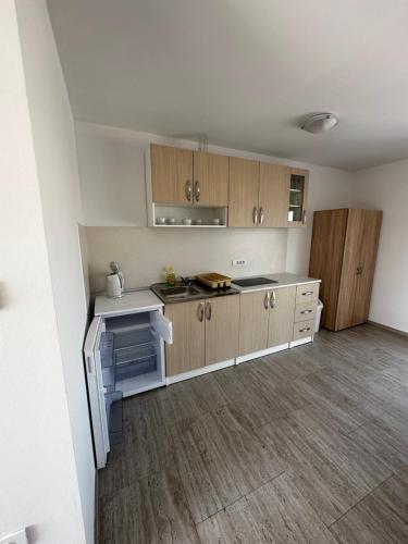 an empty kitchen with wooden cabinets and an oven at Apartmani Tamaris in Murter