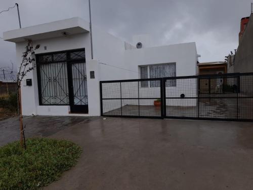 a white house with a gate in front of it at KaVa in Rawson