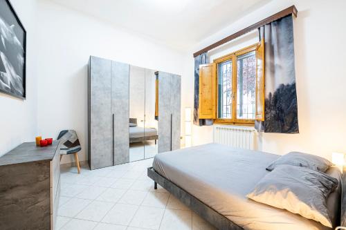 1 dormitorio con cama, escritorio y ventana en Camera 'Dolphin' - eleganza e tranquillità, en Florencia