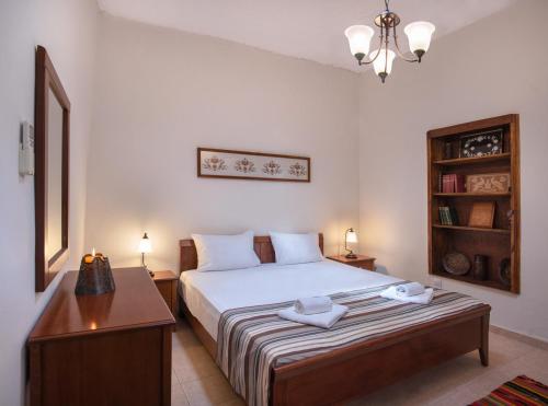 Un dormitorio con una cama y una mesa con toallas. en Feneri Traditional House Apt 1- 20' from Elafonisi beach, en Perivólia