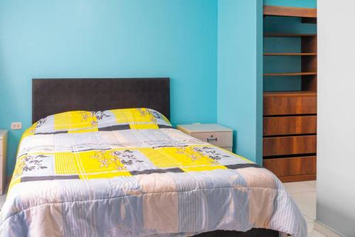 1 dormitorio con 1 cama con manta amarilla y morada en departamento moderno en surco., en Lima