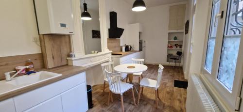 a kitchen with a table and chairs and a sink at Au coin caché in Dole