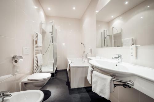 a white bathroom with a toilet and a sink at Seefelds Bed & Breakfast in Seefeld in Tirol