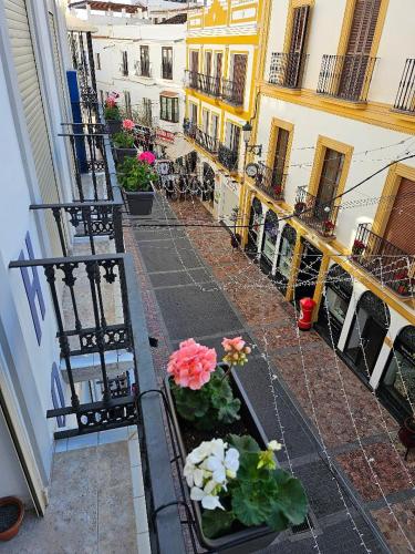 a view of a balcony with flowers on a building at Hostal Luna de Nerja in Nerja