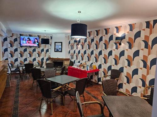 a dining room with tables and chairs and a tv at Hostal Luna de Nerja in Nerja