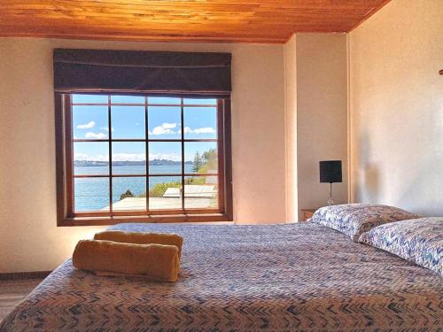 a bedroom with a large bed with a large window at Habitación privada, vista al mar 1 in Ancud