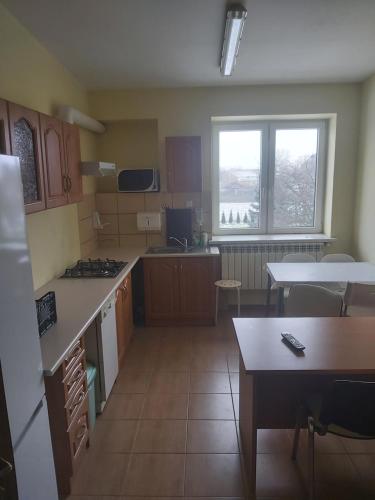 eine kleine Küche mit einem Tisch und eine Küche mit einer Arbeitsplatte in der Unterkunft MeeMo 1 - hostel dla Firm in Łyszkowice