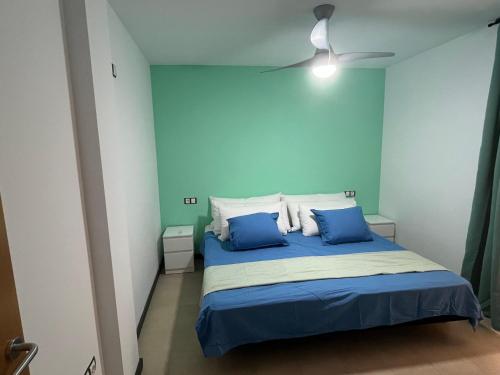 コティージョにあるCasa Teri - Los Lagosのベッドルーム1室(青い壁、青い枕付きのベッド1台付)