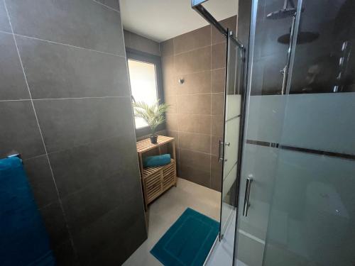 La salle de bains est pourvue d'une douche avec une porte en verre. dans l'établissement Casa Teri - Los Lagos, à El Cotillo