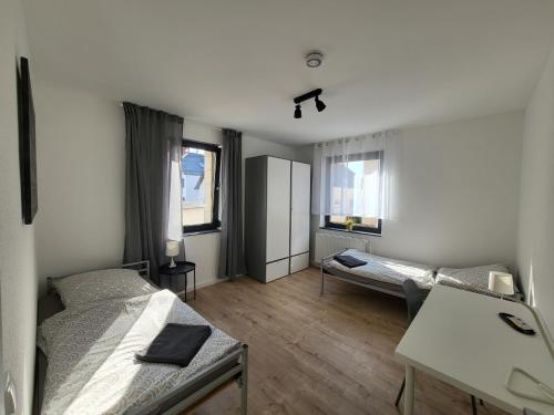 a room with two beds and a desk in it at MyTimeHouse in Ober-Ramstadt