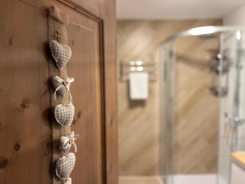 a bathroom with a shower and a door with seashells at My Dolomites Home in Livinallongo del Col di Lana