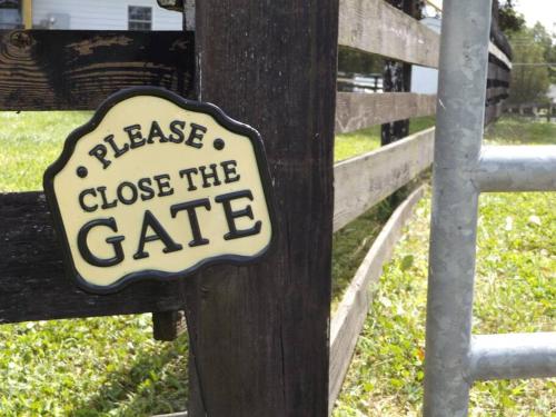 a sign on a fence that reads please close the gate at The Ranch in Mt Airy in Mount Airy