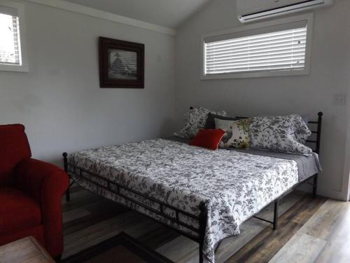 1 dormitorio con 1 cama y 1 silla roja en The Ranch in Mt Airy, en Mount Airy