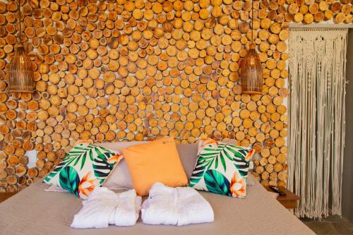 Habitación con sofá con almohadas y pared. en Glamping en Guatape Wifi Jacuzzi, en Guatapé
