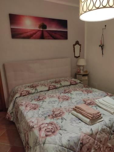 a bedroom with a bed with pink roses on it at La Bouganville e Il Gelsomino in Pietrasanta