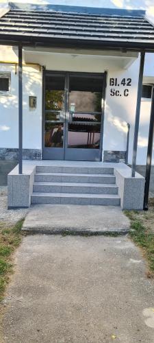a white building with steps and a window and a building at White rezidence II in Curtea de Argeş