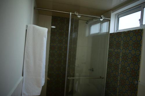 a bathroom with a shower with a glass door at Cabaña Maribel encanto in Filandia