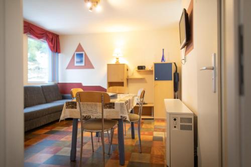 ein Wohnzimmer mit einem Tisch, Stühlen und einem Sofa in der Unterkunft Ebermannsmühle in Lauscha